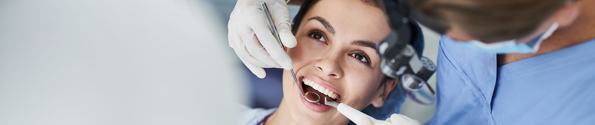 A well-lit reception area with a desk, computer monitor, and potted plant.